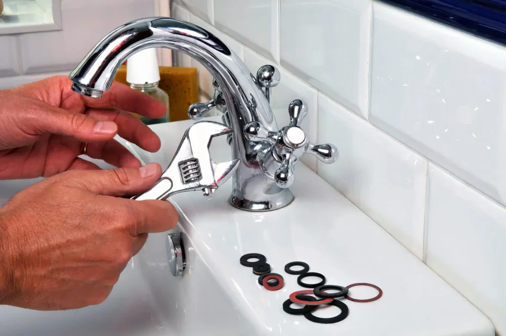 Plumber performing maintenance on a bathroom faucet in Rome