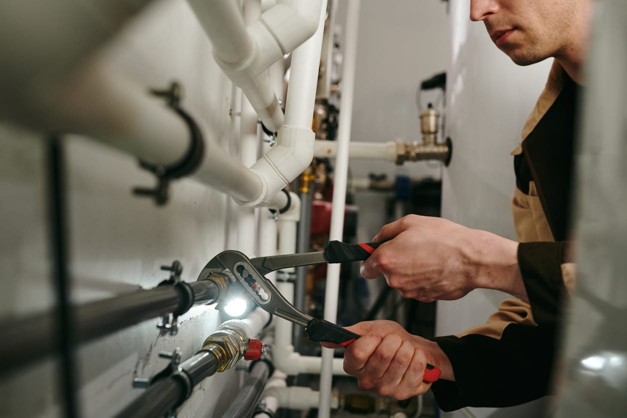 Plumbers maintaining commercial plumbing pipes in Rome
