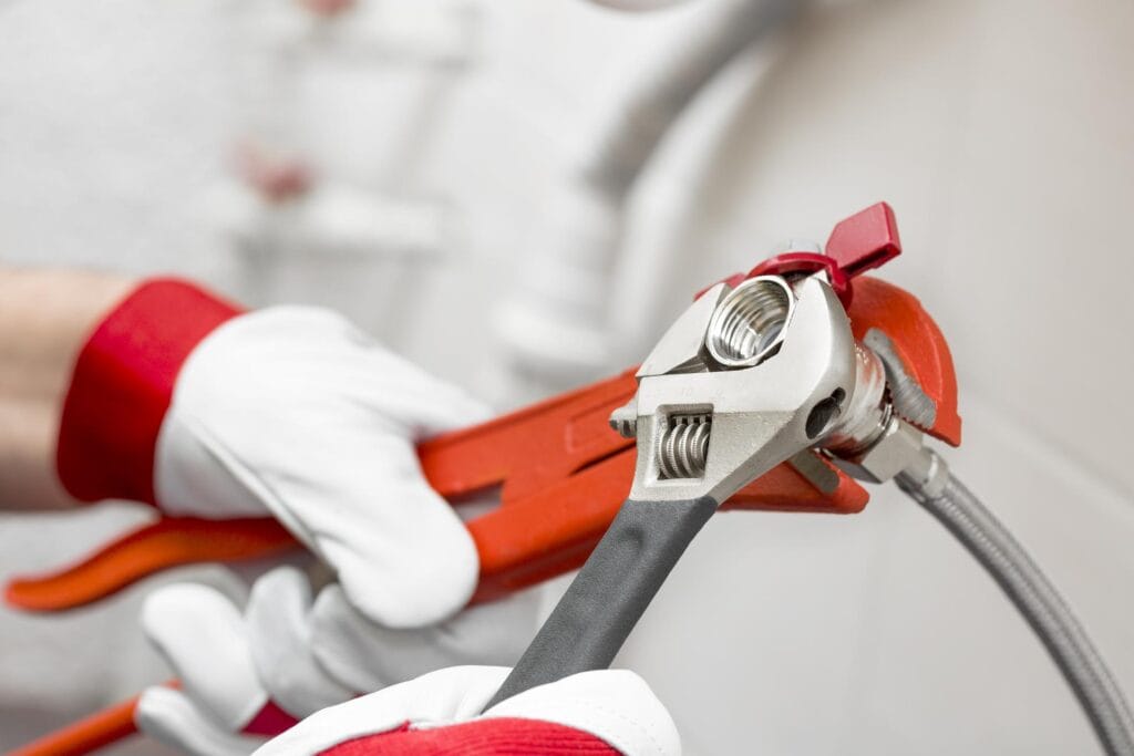 Plumber holding pipe wrenches for an emergency repair in Rome