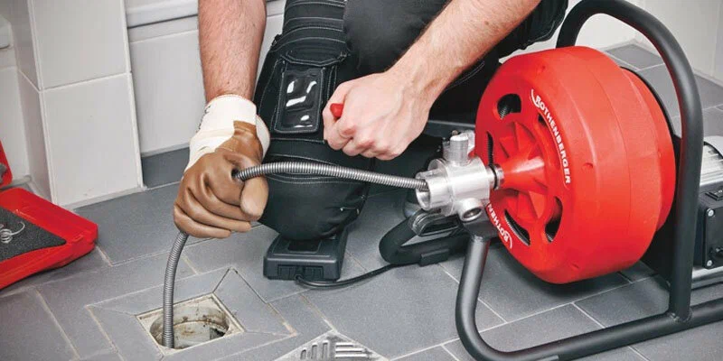 Plumber using a drain-cleaning machine in Rome