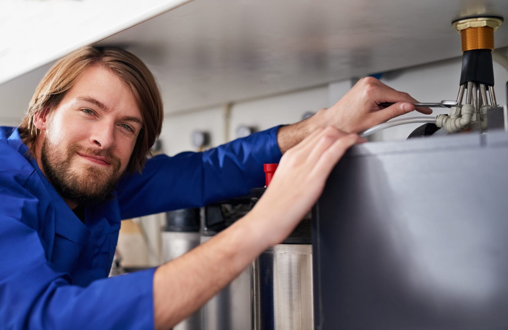 Technician servicing a residential water heater tank in Rome